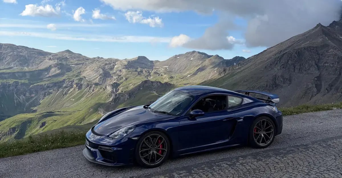 Gentian Blue Porsche 718 Cayman GT4 on an Alpine mountain pass, financed by Elev8