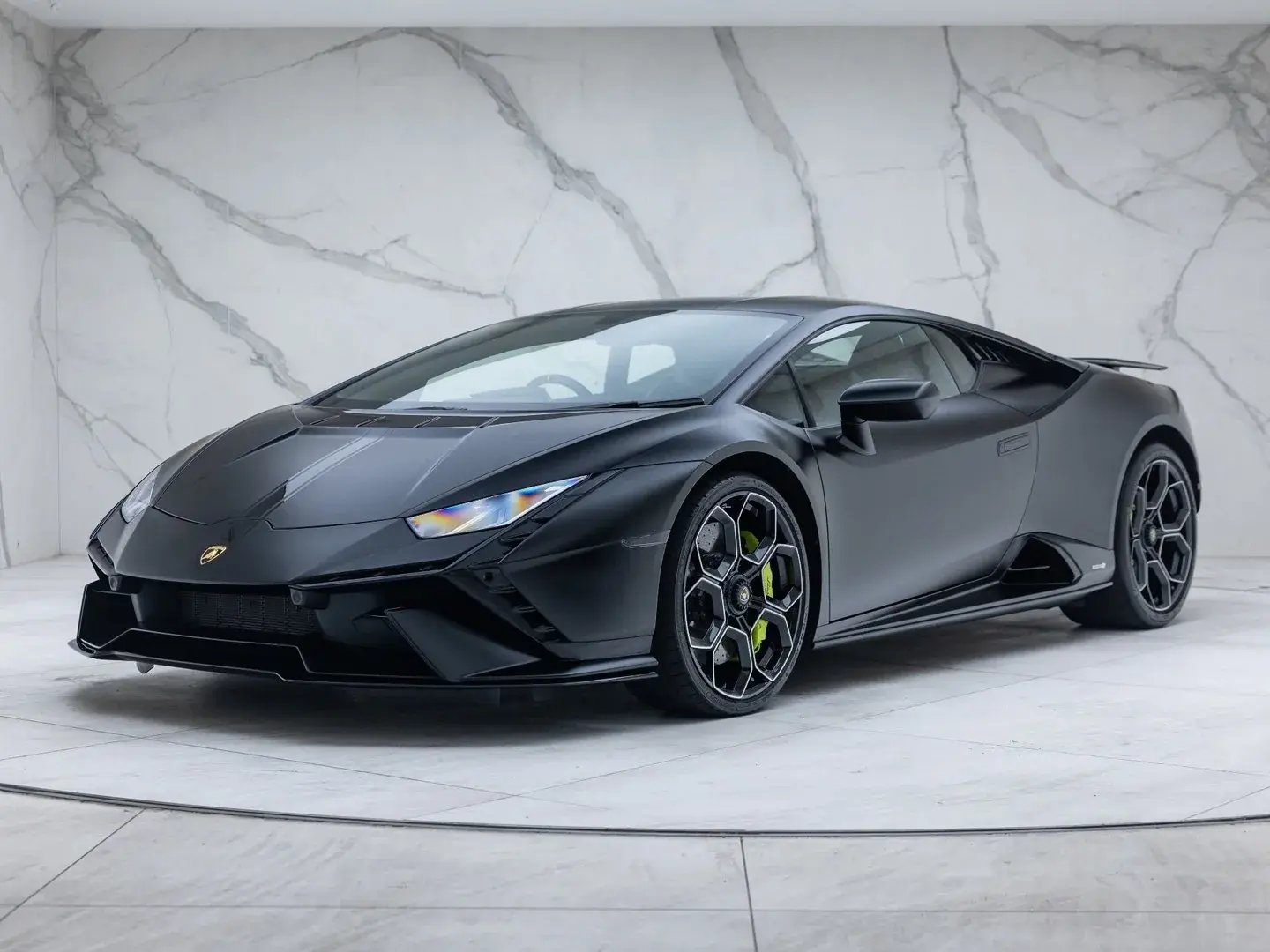 Black Lamborghini Huracán Tecnica, front three-quarter view in a showroom