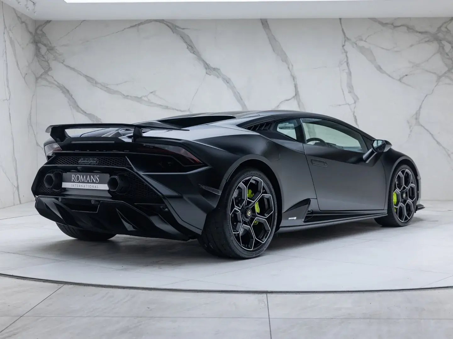 Black Lamborghini Huracán Tecnica, rear three-quarter view in a showroom