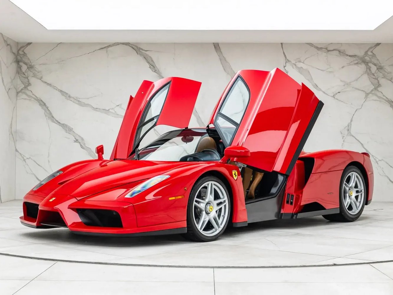 Rosso Corsa Ferrari Enzo with its doors raised, front three-quarter view